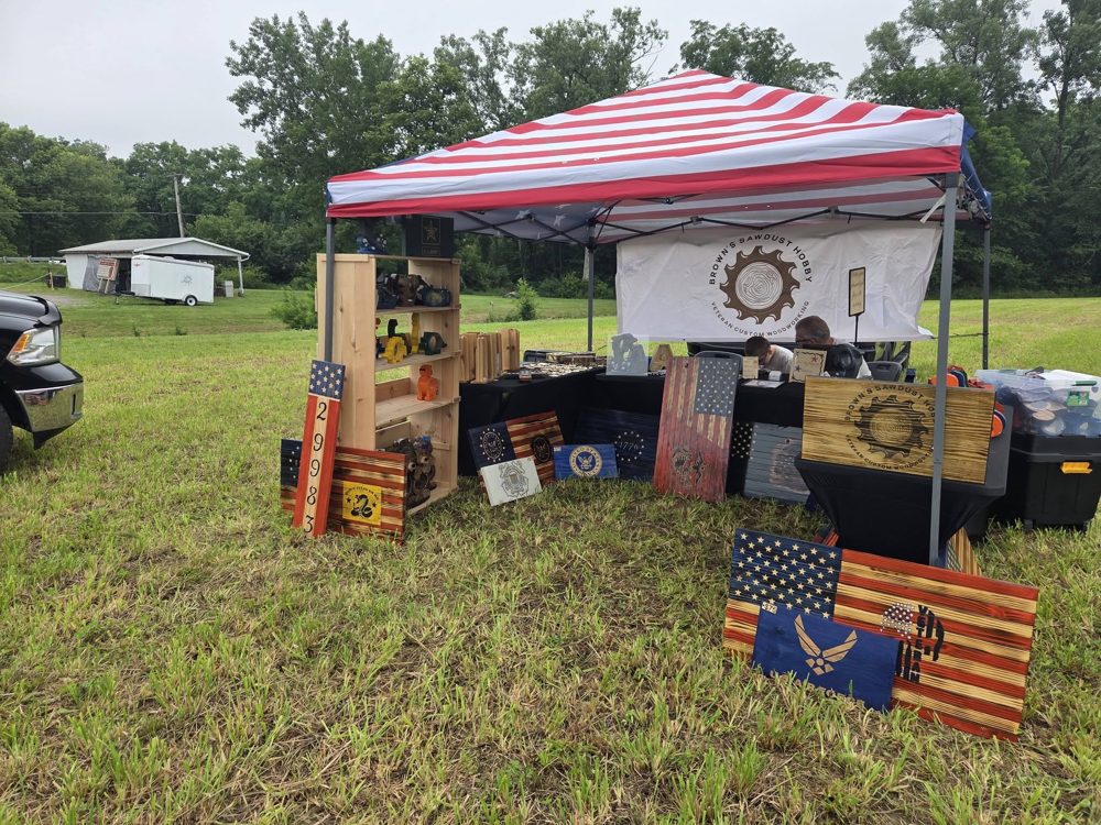 The full Brown's Sawdust Hobby outdoor booth setup with flags out front